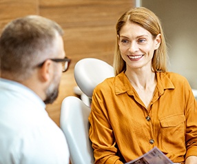 Smiling woman talking to dentist at consultation